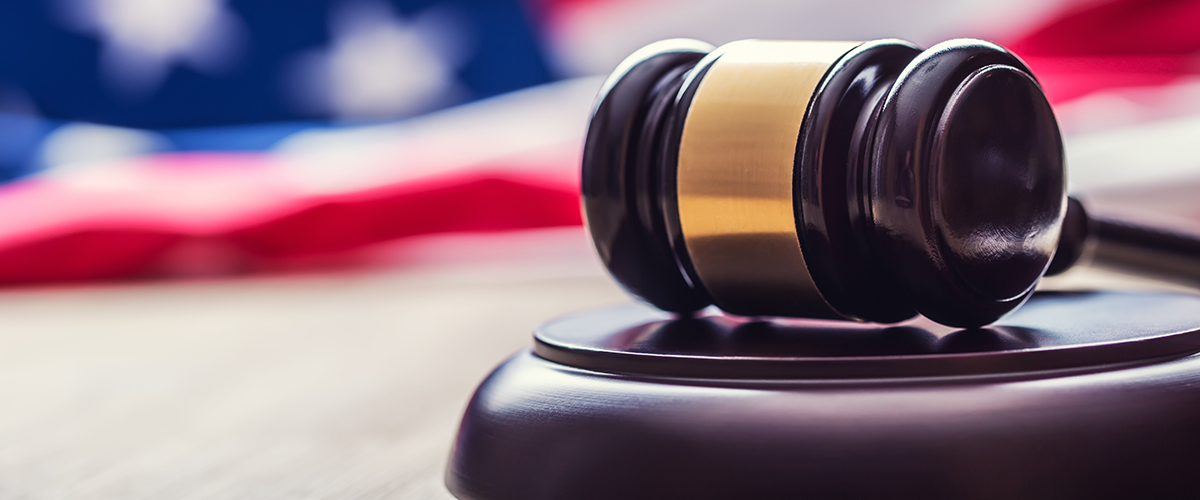 Judges wooden gavel with USA flag in the background. Symbol for jurisdiction.