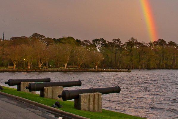 Cannons on the waterfront with a rainbow in the sky